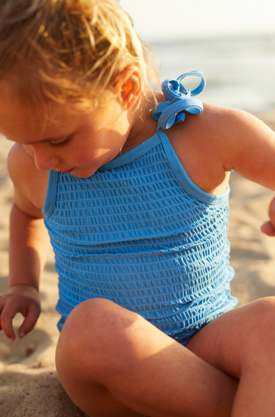 Girls scrunch one piece swimsuit in bright blue. Sizes 3 months to 10 years old.